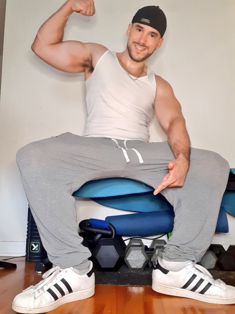 Cole Colossus (@colecolossus), schwules Tiktok-Onlyfans-Model, sitzt und spannt seine Armmuskeln